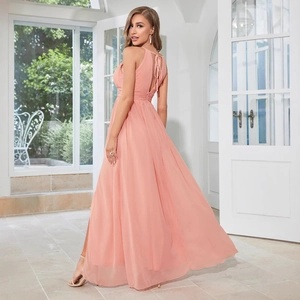 Élégante robe de soirée dos nu en mousseline corail avec licou et jupe longue à fente latérale