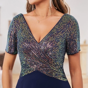 Gros plan d'une robe bleu foncé avec des paillettes rayées sur le col en V et les manches