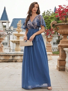 Detail of elegant evening gown with blue lace embroidery, V-neck, and bow waist tie