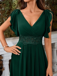 Détail d'une robe de soirée col en V avec manches volantées et dentelle brodée à la taille
