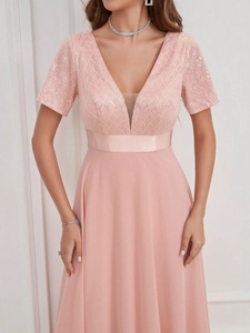 Détail de robe de soirée rose avec bustier en dentelle pailletée, col en V et ceinture satin