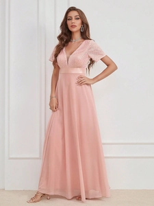 Détail d'une robe de soirée rose avec broderie en dentelle pailletée et col en V