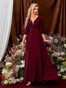 Detail eines eleganten dunkelroten Abendkleids mit V-Ausschnitt und Plissee-Taille