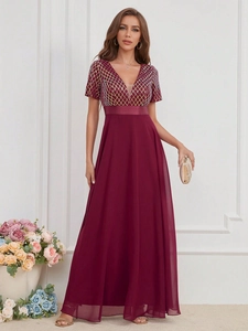 Détail de la robe de soirée bordeaux avec résille à paillettes dorées et ceinture large