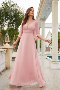 Detailed view of the elegant V-neckline and pleated bell sleeves on a blush pink gown