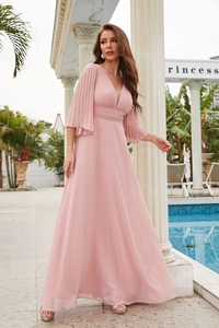 Detail of pink chiffon evening gown featuring a deep V-neck and pleated flutter sleeves