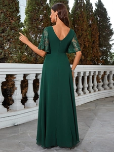 Détail d'une élégante robe de soirée vert foncé avec manches en dentelle et dos en V profond