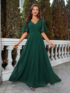 Détail d'une élégante robe de soirée vert foncé avec col en V, dentelle et taille plissée