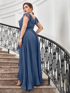Close-up of the V-neckline and layered ruffle shoulder details on the dusty blue dress