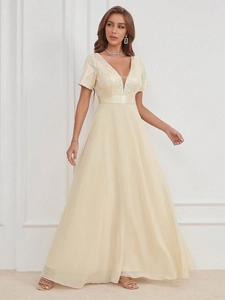 Détail de la texture mesh à paillettes et ceinture en satin sur robe de soirée champagne