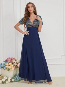 Détail du décolleté en V pailleté avec motifs géométriques sur la robe en mousseline
