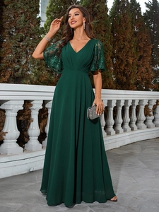 Détails d'une robe de soirée vert foncé avec col en V, manches en dentelle et jupe en mousseline