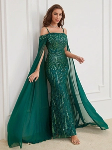 Close-up of dark green sequin gown with elegant long chiffon cape and off-shoulder straps