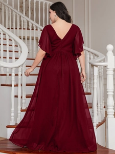 Detail of burgundy V-neck evening gown with flowing chiffon fabric and ruffled sleeves