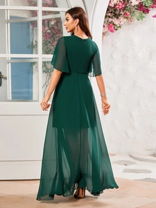 Dettaglio di un abito da sera in chiffon verde scuro con maniche a balze e design a strati