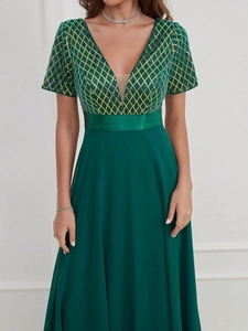 Détail du bustier à paillettes et de la jupe en mousseline vert émeraude sur la robe