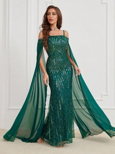 Detail of dark green sequins on evening dress with long sheer cape sleeves