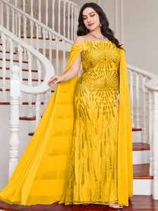 Detail of shimmering yellow sequined evening gown with long cape sleeves on a spiral staircase