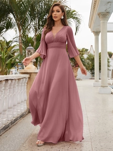 Close-up of elegant V-neck chiffon evening gown with pleated waist in dusty rose pink