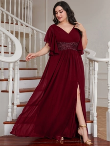 Detail of burgundy evening gown featuring a sequined belt and elegant pleated high-slit skirt