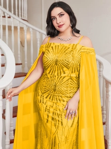 Detailed view of the bright yellow sequined dress featuring radiant gold patterns and cape sleeves