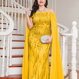 Close-up detail of yellow sequin evening gown with chiffon cape sleeves and radiant patterns