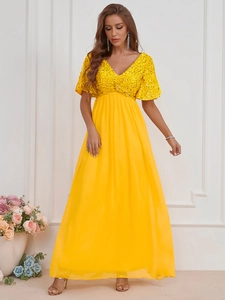 Détail de la robe longue en mousseline jaune avec corsage à paillettes scintillantes et col en V