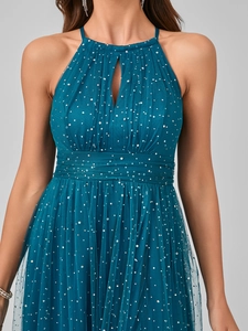 Detailed view of the dark teal tulle gown featuring silver sequins and a halter neckline