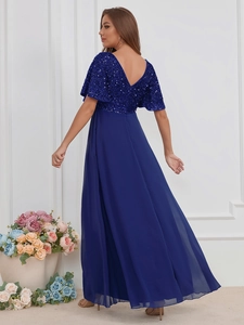 Détail d'une robe de soirée bleu marine avec corsage à paillettes et jupe en mousseline