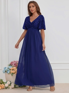 Détail d'une robe de soirée col en V élégante avec haut à paillettes et jupe mousseline