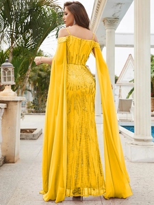 Detail of yellow sequin evening gown featuring floor-length cape sleeves and slim fit