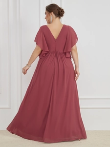 Detailed back view of a dusty pink V-neck gown with ruffled sleeves and flowing hemline