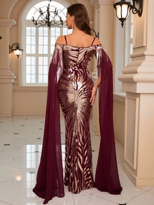 Detailed view of burgundy sequined gown with metallic tassels and flowing chiffon sleeves