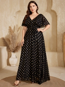Detail of V-neck plus size maxi dress with black and gold polka dot print and waist tie