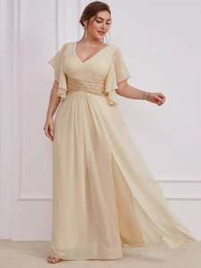 Close-up of V-neck evening gown with golden sequin waist detail and high split skirt