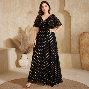 Macro detail of V-neckline and golden polka dot chiffon fabric on black maxi dress