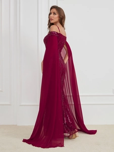 Detail of burgundy sequin evening gown featuring elegant cape sleeves and floor-length hem
