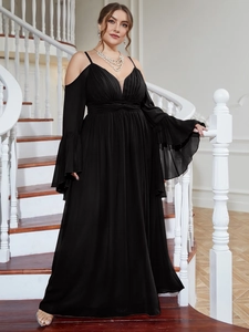 Detail of elegant black cold shoulder evening gown with v-neck on spiral stairs