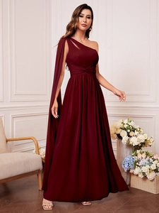 Détail d'une élégante robe de soirée bordeaux à une épaule avec manche cape et taille plissée