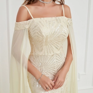 Detail of sequins embroidery and draped cape sleeves on champagne evening dress
