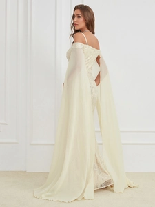 Detail of off-shoulder evening dress featuring silver sequins and airy chiffon shawl sleeves