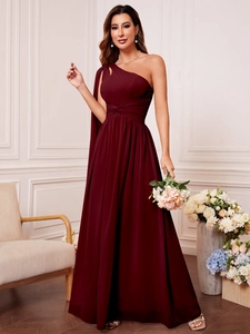 Détail de la robe de soirée en mousseline bordeaux avec taille plissée et coupe asymétrique