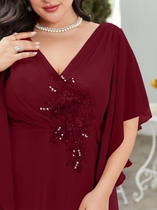 Detailed view of burgundy chiffon gown with floral lace embroidery and pearl beads