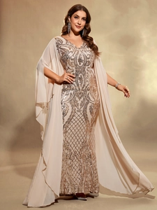 Close-up of elegant apricot chiffon evening gown with golden sequin embroidery and cape