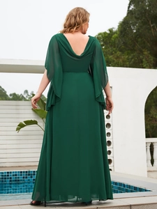 Detail of the elegant dark green chiffon backless gown with cape sleeves and draped neckline