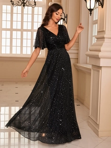 Detailed view of sparkly sequin fabric on a black V-neck evening gown with ruffle sleeves
