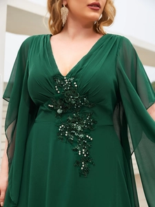 Detail of dark green evening dress with floral embroidery, pearls and sequins