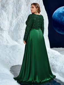 Detailed view of emerald green evening dress featuring sequin embroidery and satin pleats