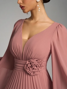 Detail of pink chiffon dress featuring pleated skirt and 3D floral waist decoration