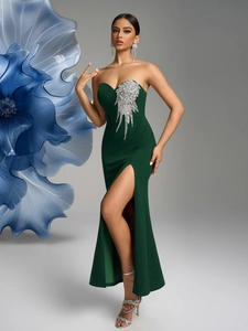 Detail of dark green evening gown with silver sequined wing pattern and thigh-high slit